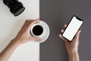 Minimalist workspace featuring a smartphone and black coffee, perfect for productivity and relaxation.